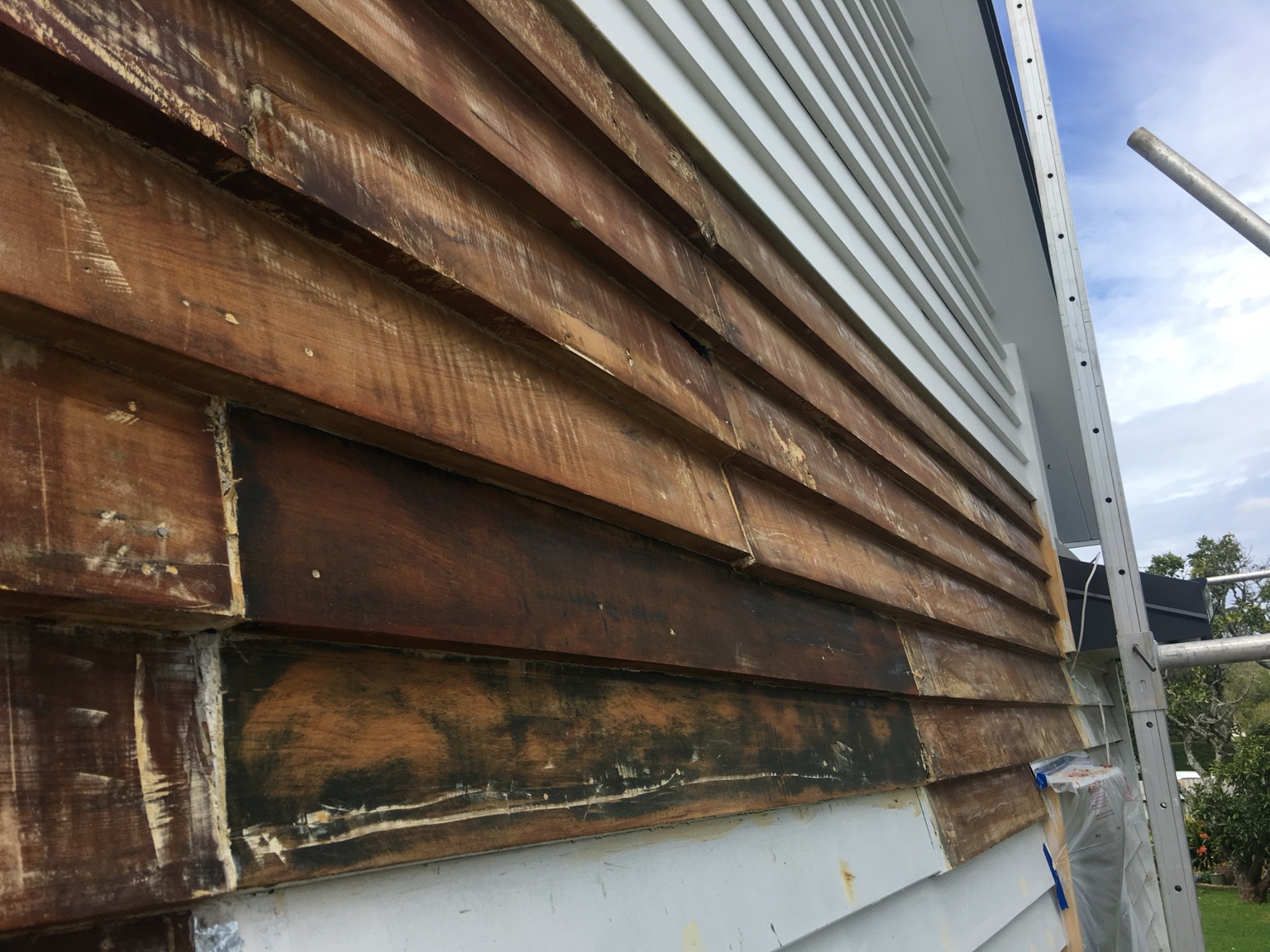 Before damaged darkened weatherboards