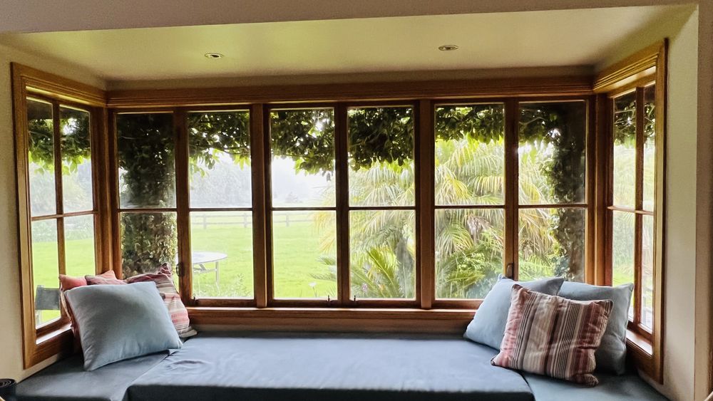 Auckland villa weatherboards mid-strip with scaffolding, raw kauri timber revealed